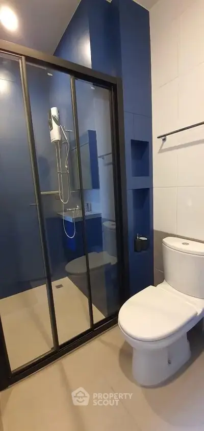 Modern bathroom with sleek glass shower and blue accent wall