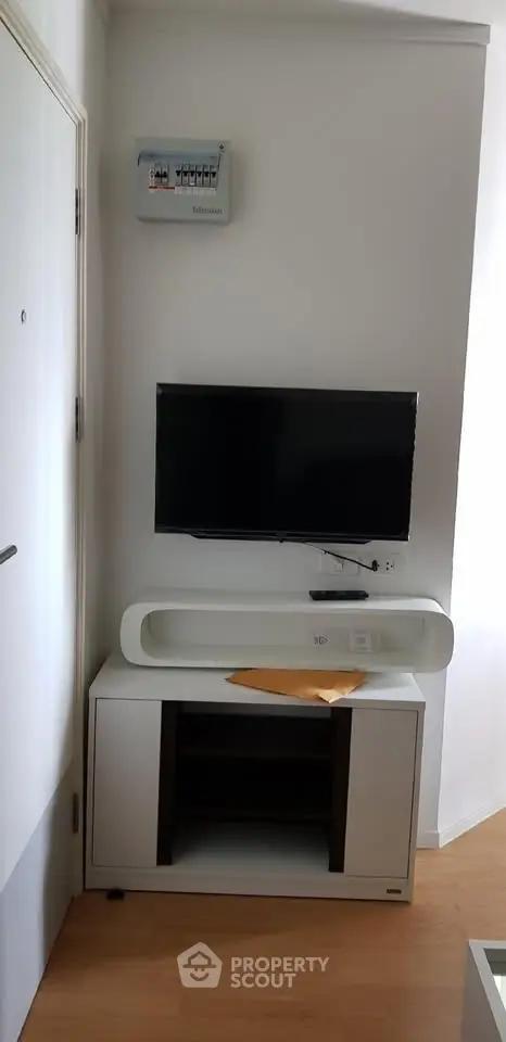 Modern living room corner with wall-mounted TV and sleek cabinet