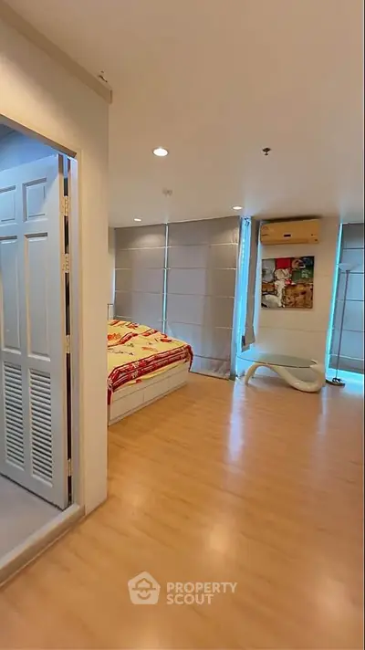 Spacious bedroom with modern decor and large windows in a stylish apartment.