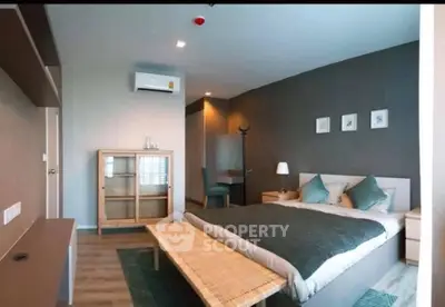 Modern bedroom with stylish decor and natural light, featuring a cozy bed and elegant furnishings.