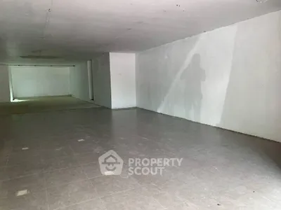 Spacious unfinished basement with tiled flooring and white walls, ideal for customization.