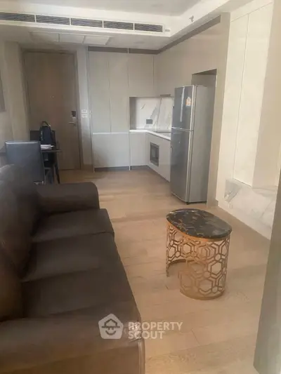 Modern living room with sleek kitchen and stylish furniture in a contemporary apartment.