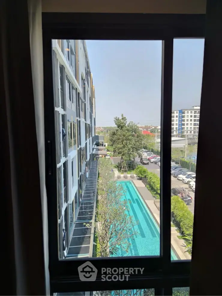 Stunning pool view from a modern apartment window, showcasing urban living with lush greenery and cityscape.