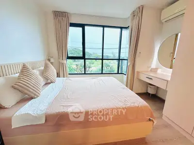 Bright and cozy bedroom with large windows and modern decor, offering a serene view.