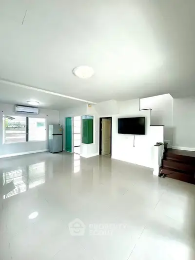 Spacious modern living room with sleek staircase and natural light