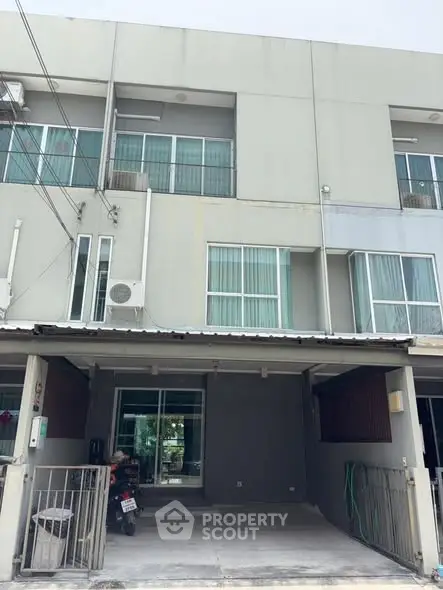 Modern townhouse exterior with parking space and large windows