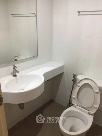 Compact bathroom with modern sink and toilet in minimalist design.