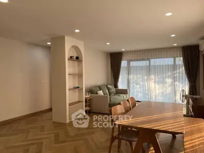 Spacious living room with elegant wooden flooring and modern furniture, perfect for relaxation and entertainment.