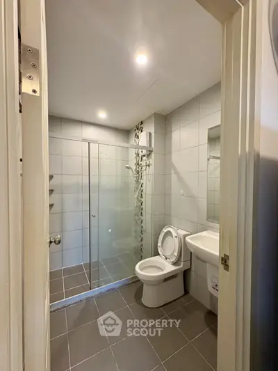 Modern bathroom with glass shower and sleek fixtures in a contemporary home.