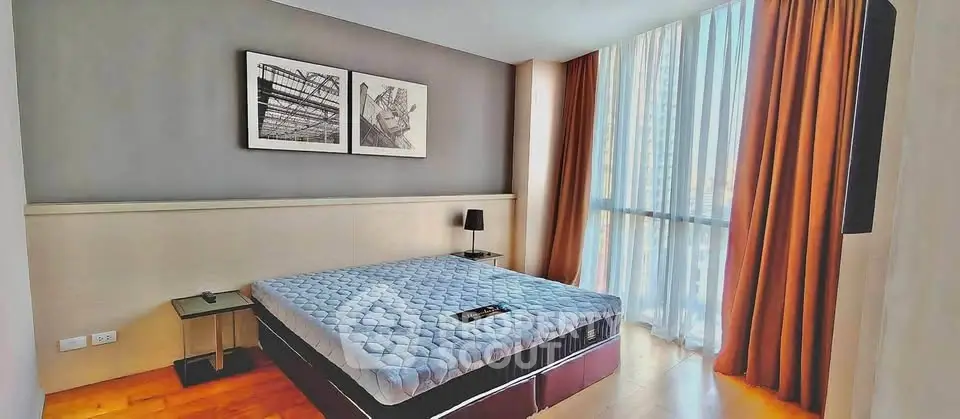 Spacious modern bedroom with large window and stylish decor in a luxury apartment.