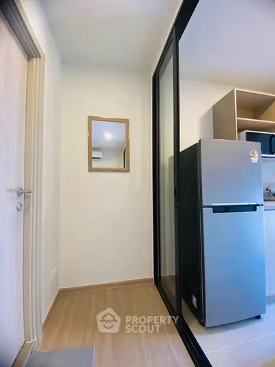 Modern kitchen with sleek fridge and microwave in compact space