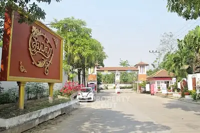 Charming gated community entrance with lush greenery and welcoming signage.