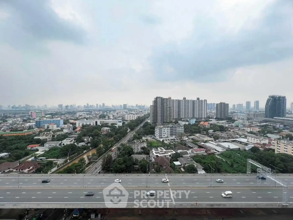 Stunning cityscape view from high-rise building overlooking urban skyline and highway.