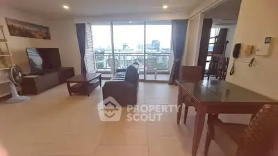 Spacious living room with city view and modern furnishings in high-rise apartment.