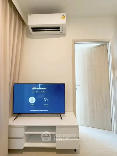 Modern living room with air conditioning and flat-screen TV, minimalistic design.