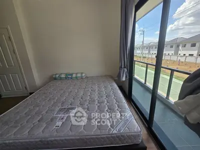 Spacious bedroom with large window and balcony view in modern home