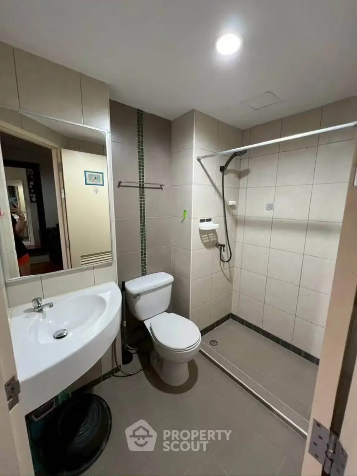 Modern bathroom with walk-in shower and sleek fixtures in a contemporary apartment.