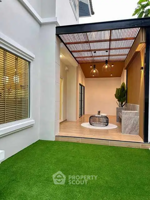 Modern patio with stylish pergola and lush green lawn