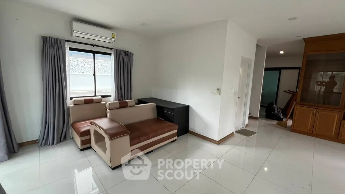 Spacious living room with modern furniture and large window for natural light.