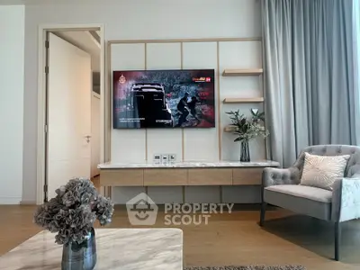 Modern living room with stylish decor and wall-mounted TV, featuring elegant furniture and natural light.