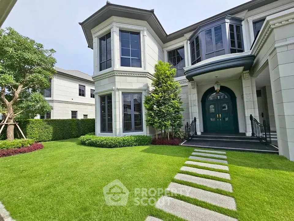 Elegant luxury home exterior with manicured lawn and grand entrance