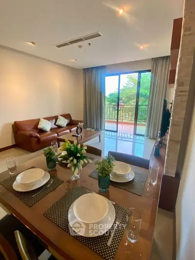 Spacious living room with elegant dining area and balcony view
