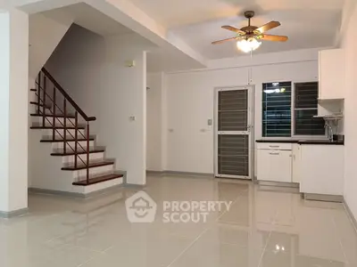 Spacious open-plan living area with modern kitchen and staircase