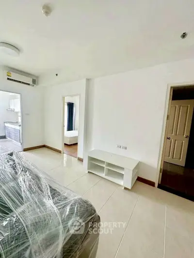 Modern apartment interior with sleek design and natural light, featuring a partially furnished living area.