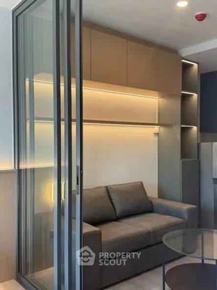 Modern living room with sleek glass partition and cozy sofa