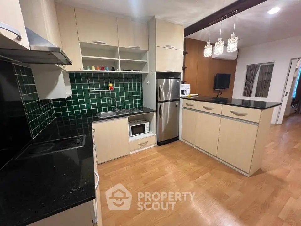 Modern kitchen with sleek appliances and stylish green tile backsplash