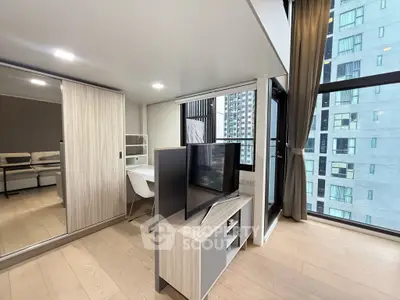 Modern living room with sleek furniture and large windows in a high-rise apartment.