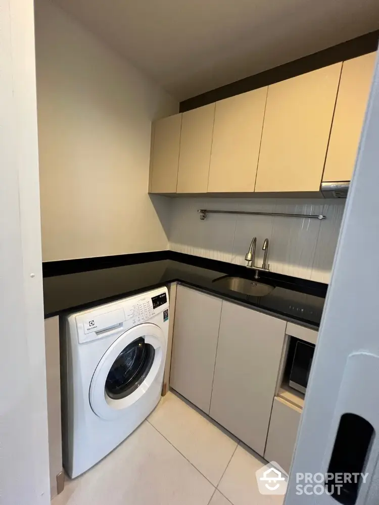 Modern compact kitchen with washing machine and sleek cabinetry