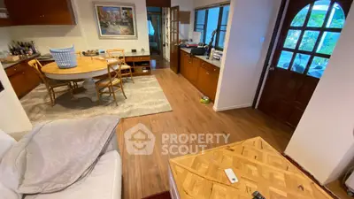 Charming open-layout living and dining area with wooden flooring and natural light.