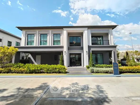 Stunning modern two-story house with lush landscaping and spacious driveway.
