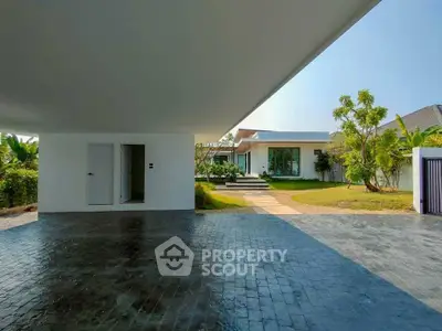 Modern minimalist home with spacious driveway and lush garden