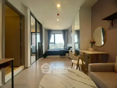 Modern studio apartment with open layout and city view, featuring stylish furniture and natural light.