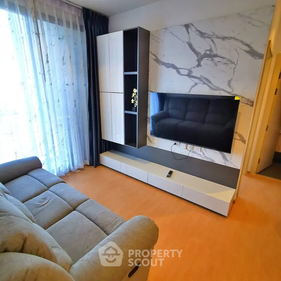 Modern living room with stylish marble accent wall and sleek entertainment unit.