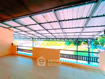 Spacious covered balcony with tiled flooring and scenic view, perfect for outdoor relaxation.