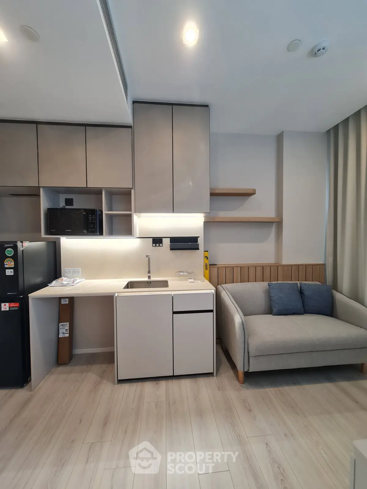 Modern living room with sleek kitchen and cozy sofa in stylish apartment