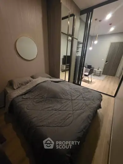 Cozy bedroom with modern decor and mirrored wardrobe in stylish apartment.