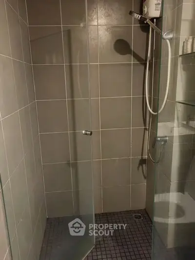 Modern bathroom with glass shower enclosure and sleek tile design.