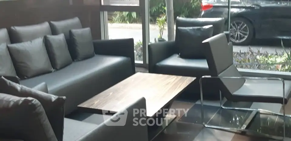 Modern lobby with sleek furniture and large windows overlooking a garden view.