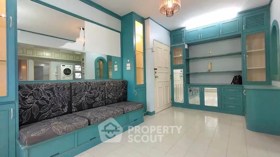 Charming living room with built-in teal cabinetry and cozy seating area.