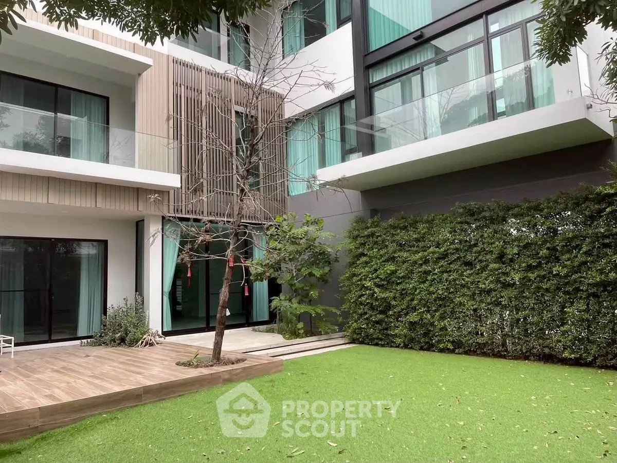 Modern building exterior with lush garden and spacious balconies, perfect for urban living.