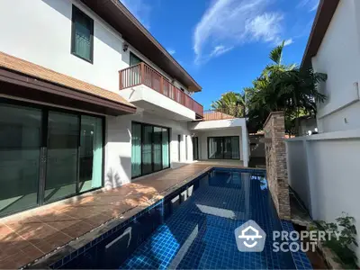 Stunning modern home with private pool and spacious balcony under clear blue skies.