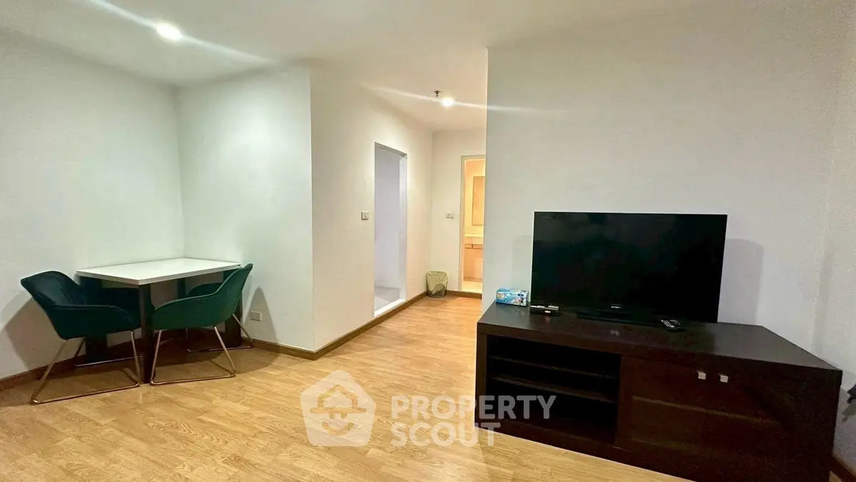 Modern living room with sleek TV stand and cozy dining area.
