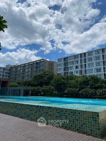 Modern apartment complex with a stunning outdoor pool and lush greenery.