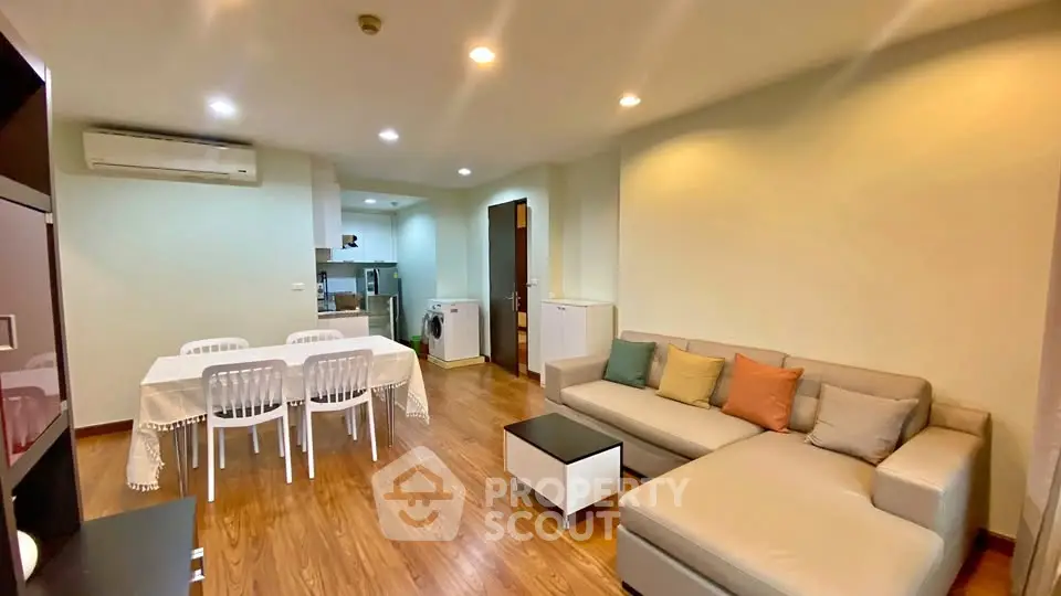 Spacious living room with modern furniture and dining area in a cozy apartment.