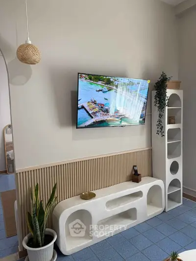 Modern living room with stylish decor and wall-mounted TV, featuring unique shelving and indoor plants.