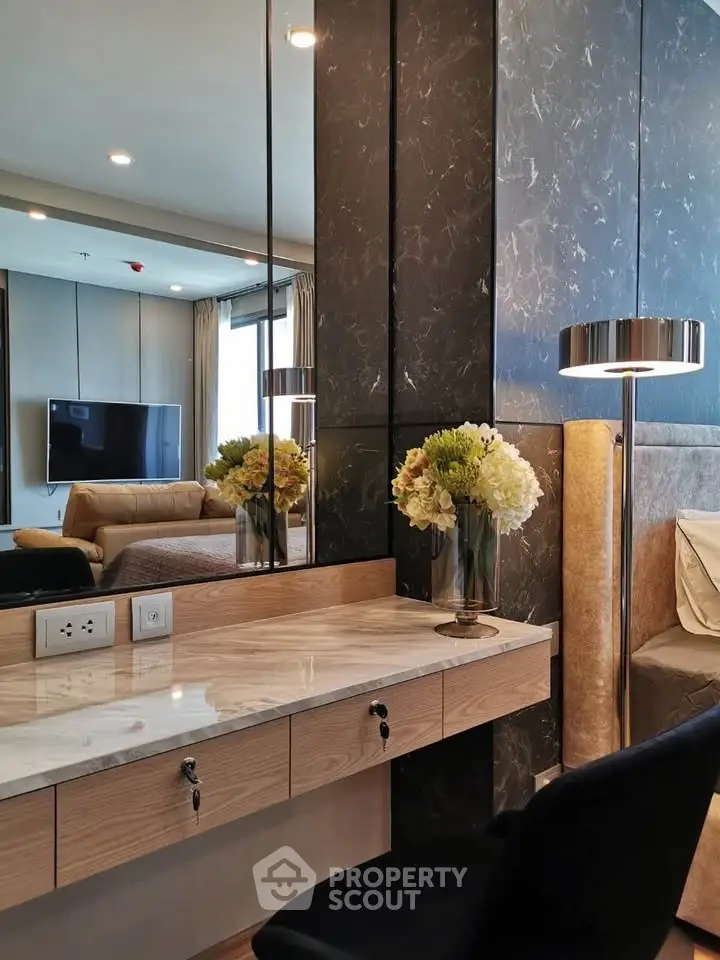 Luxurious modern living room with elegant decor and stylish furniture, featuring a marble accent wall and cozy seating.